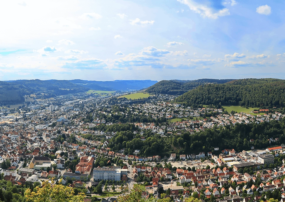 Blick auf Albstadt-Ebingen von oben mit Wohnhäusern, Stadtzentrum und umgebender Hügellandschaft der Schwäbischen Alb.