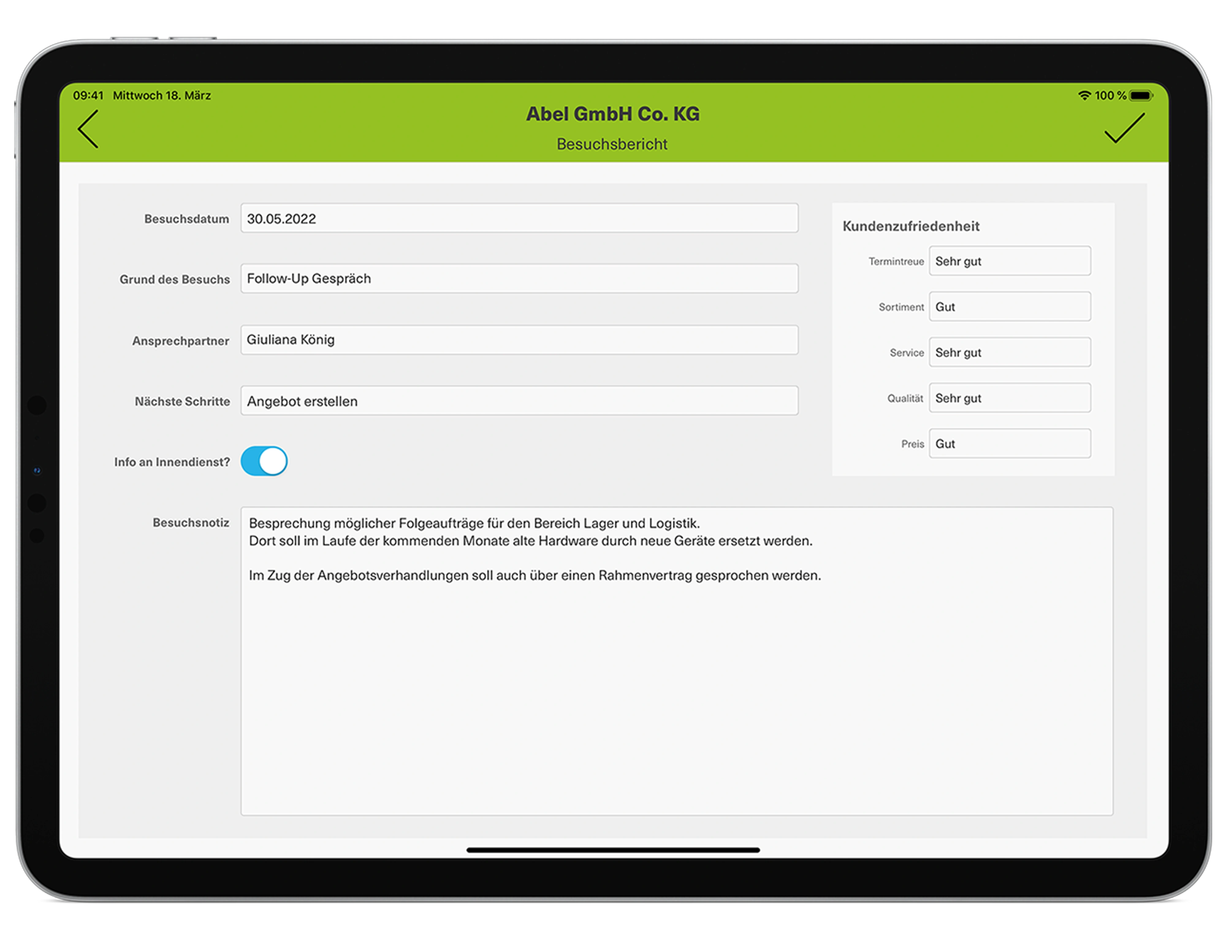 Tablet screen showing an open customer visit report app from the engomo platform. Visible are details such as visit date, purpose (follow-up), contact person (Giuliana König), planned next steps, and customer satisfaction ratings across various categories including punctuality, service, and quality. A detailed comment summarizing the meeting is shown at the bottom.