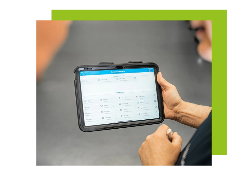 A photo of a tablet in the hands of a warehouse worker, symbolizing the solutions engomo provides.