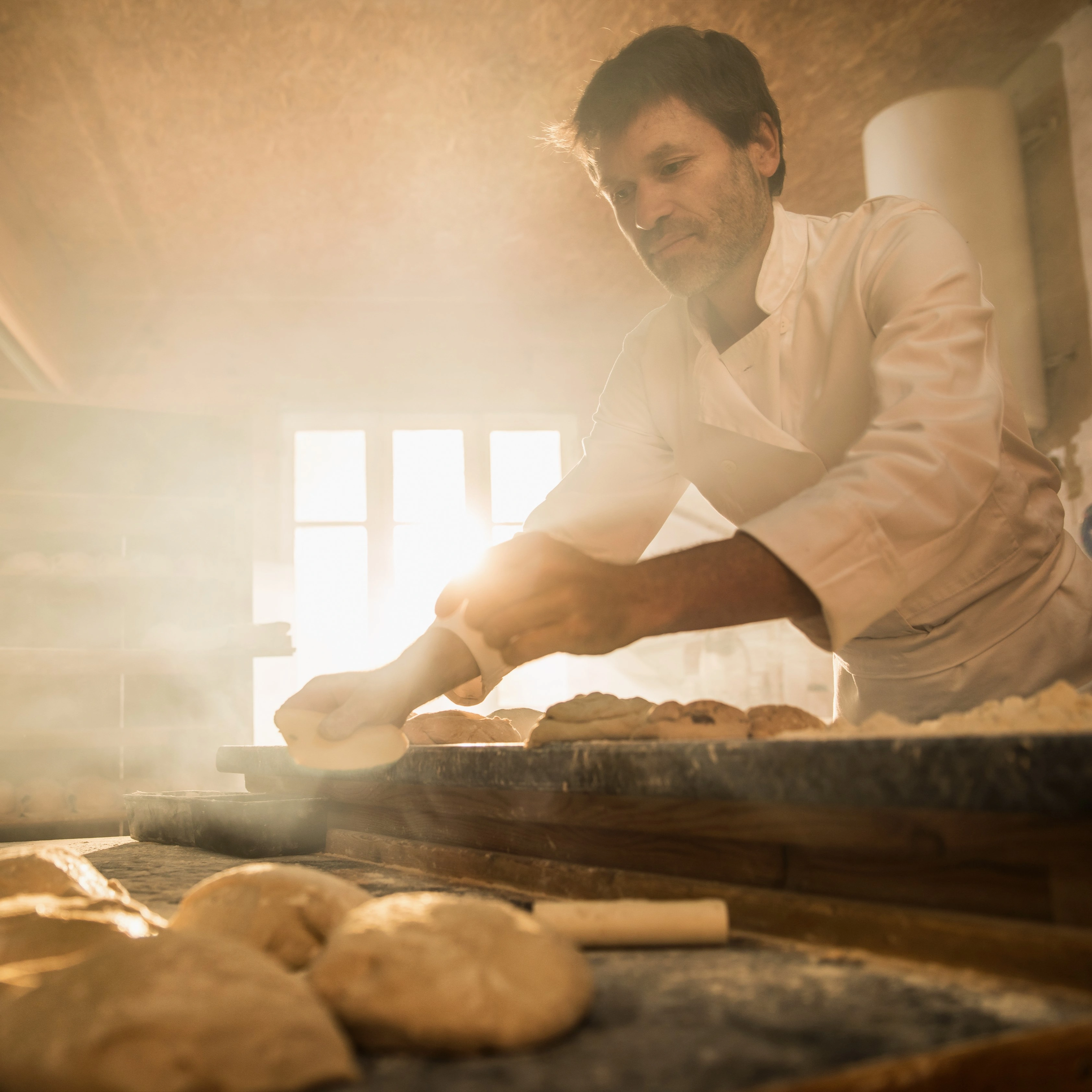 Baker working with dough in a traditional bakery – symbolizing the digitalization of manual production processes using engomo apps.