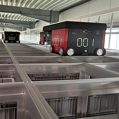 Automatisiertes Lager mit AutoStore-Robotern auf einem Schienensystem.