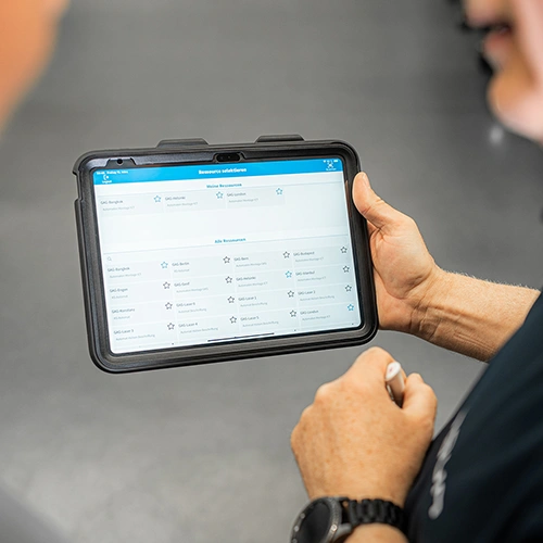 Teaserbild zum Artikel, auf dem einer Person ein Tablet in der Hand h&auml;lt und auf dessen Screen eine Fertigungs-App zu erkennen ist