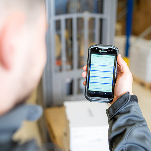 Mitarbeiter mit mobiler Erfassungs-App auf einem Handheld-Scanner im Lager &ndash; digitale Logistikl&ouml;sung auf der LogiMAT 2025