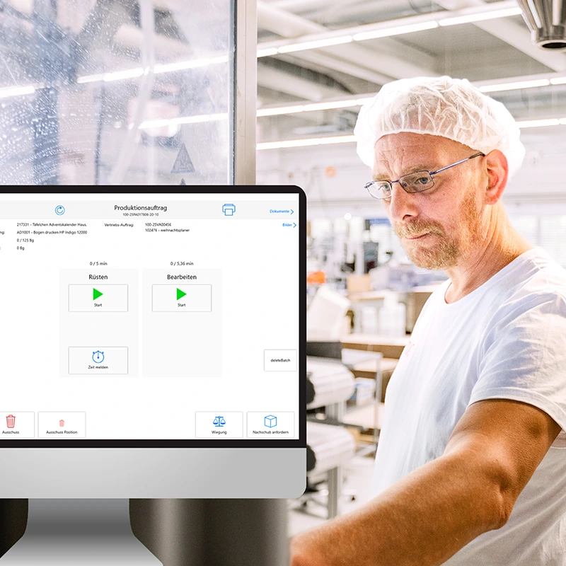 Industriearbeiter &uuml;berwacht und steuert eine Verpackungsanlage &uuml;ber ein digitales System